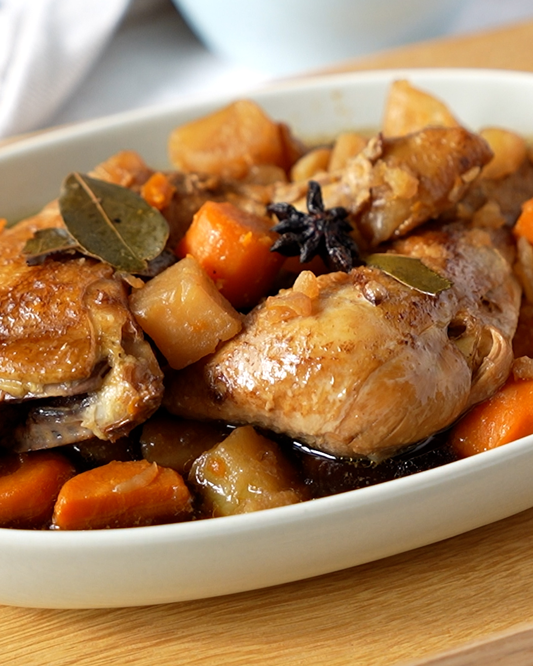 Braised chicken with potatoes and carrots cooking in pot on the stove