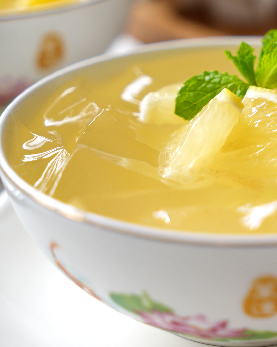 Close-up of homemade aiyu jelly with osmanthus honey syrup drizzled over, garnished with lemon