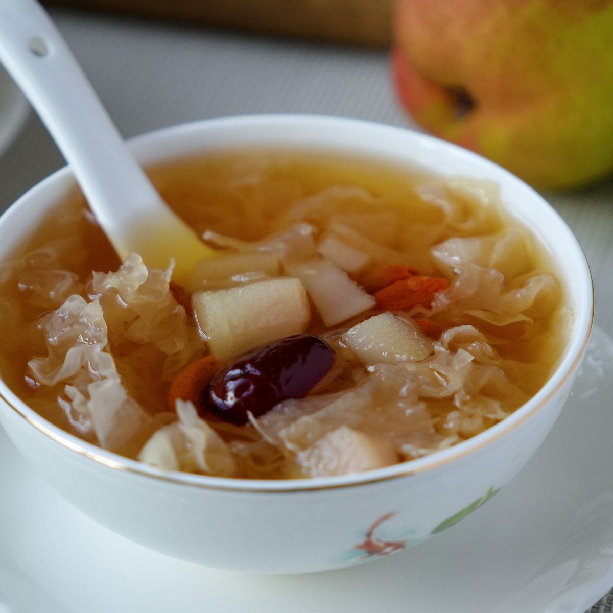 Snow fungus and pear dessert soup served in a bowl, showing the soft jelly-like snow fungus and pear pieces