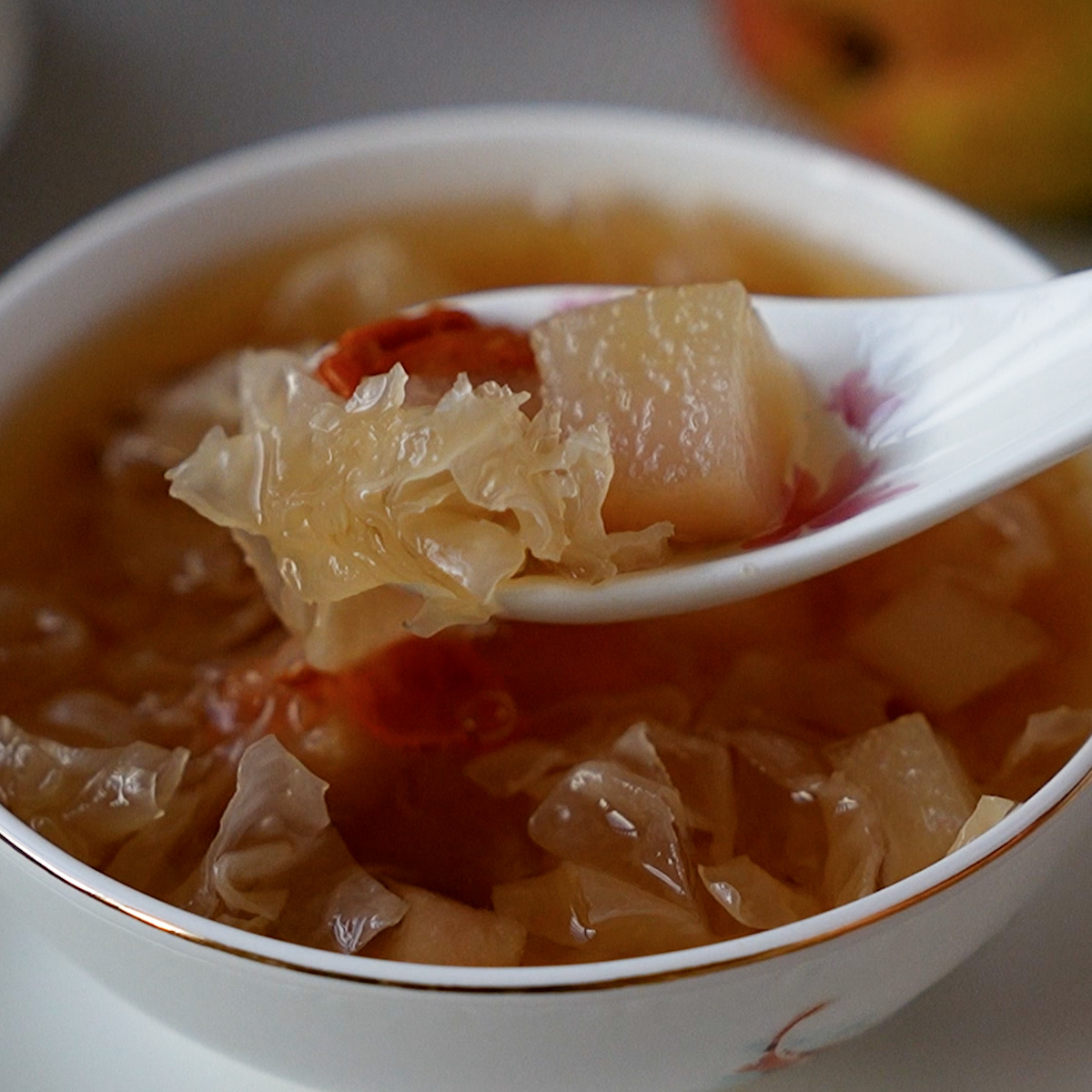 Close-up of snow fungus pear dessert soup with goji berries and red dates in a clear broth