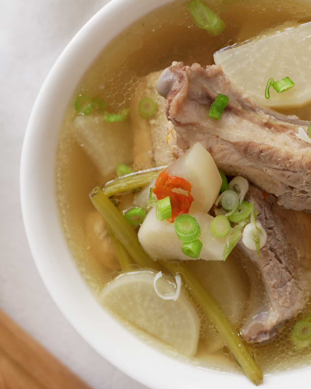 Clear pork ribs soup with radish and goji berries simmering in a pot