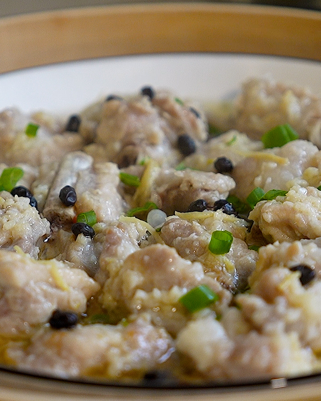 Chinese steamed pork ribs with fermented black beans served on a heatproof plate