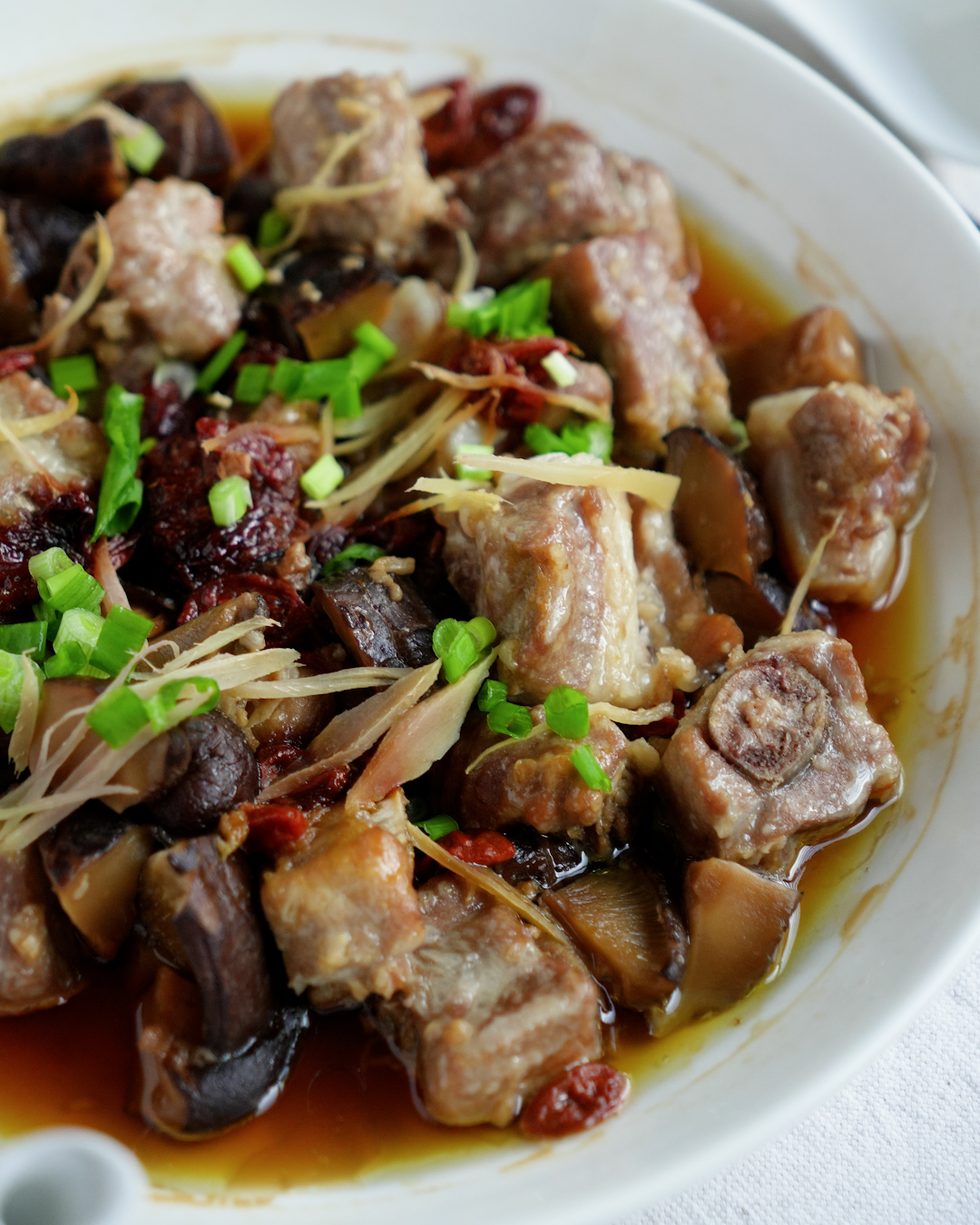Ingredients for steamed pork ribs with mushrooms: spare ribs, dried shiitake mushrooms, goji berries, garlic and ginger