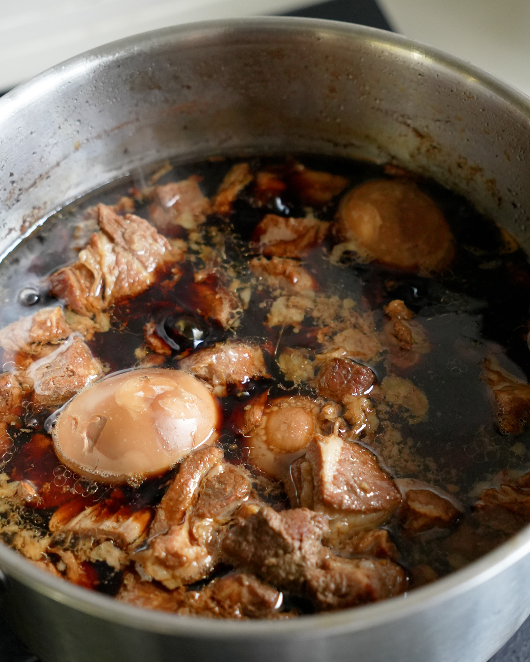 Close up of tau yu bak braised pork in soy sauce served over steamed rice