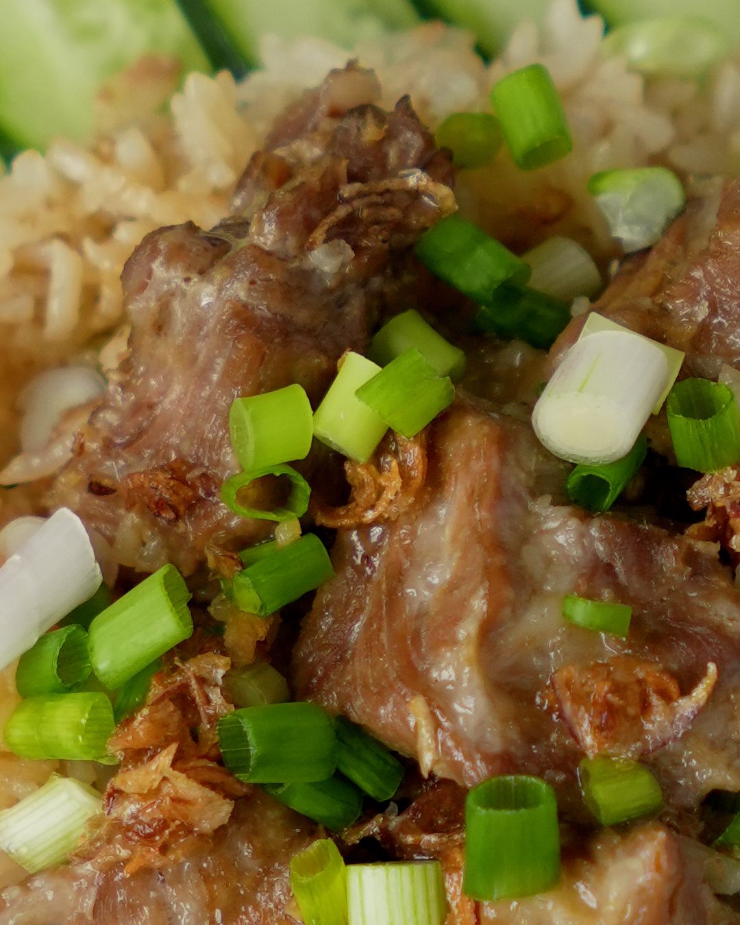 Close up of marinated pork ribs on rice cooked in a rice cooker