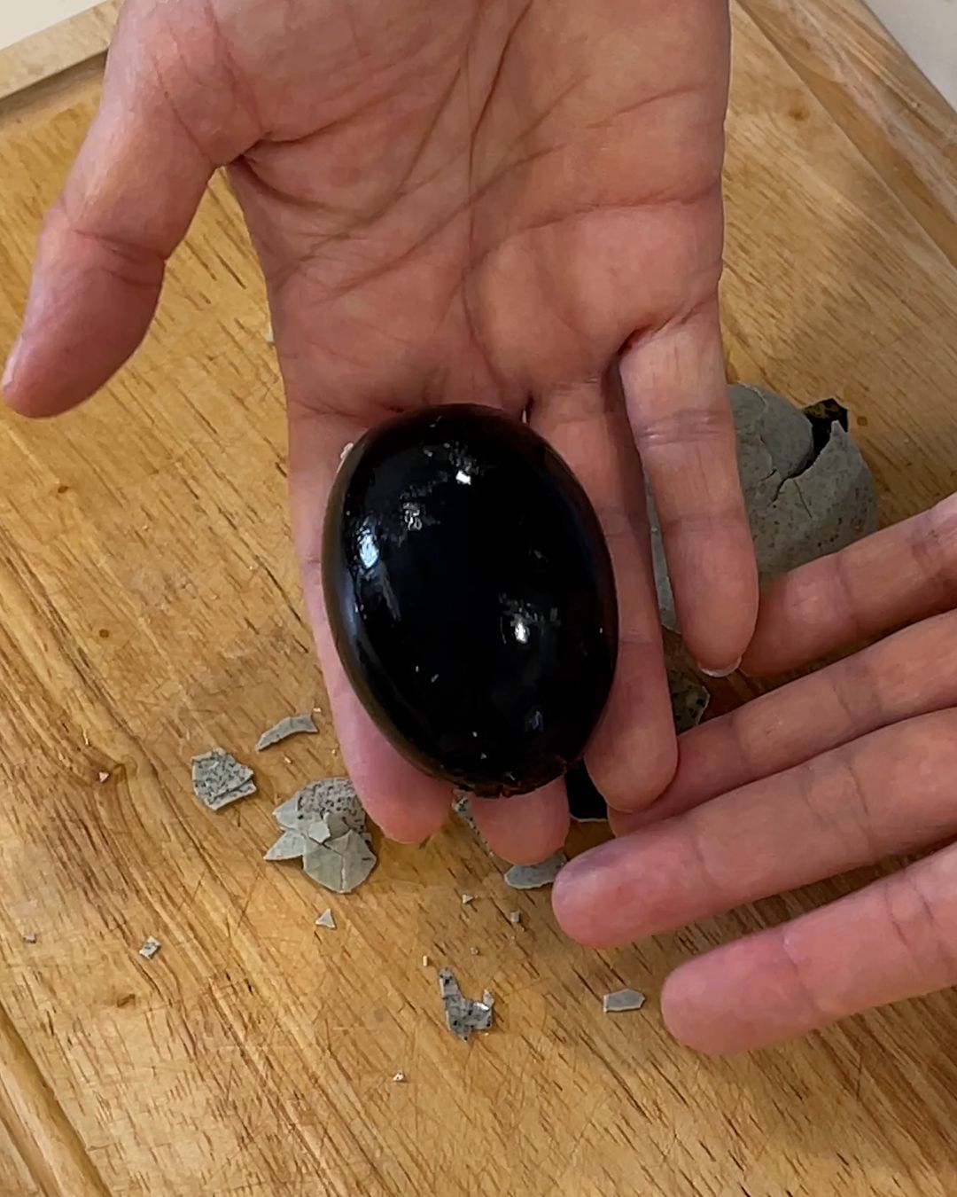 Peeled century egg showing its dark, glossy jelly-like appearance