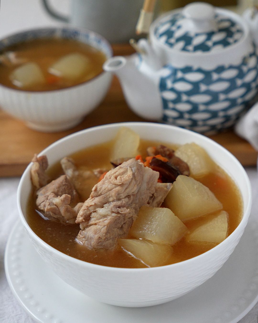 Sliced winter melon, pork ribs, red dates and goji berries laid out as ingredients for pork ribs soup with winter melon