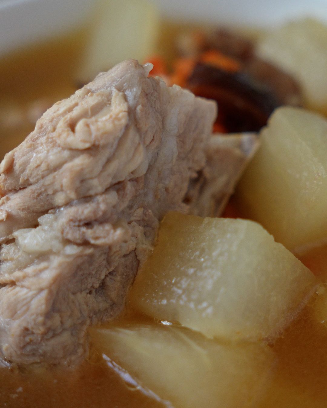 Close-up of pork ribs soup with winter melon showing tender pork ribs and translucent winter melon in clear broth