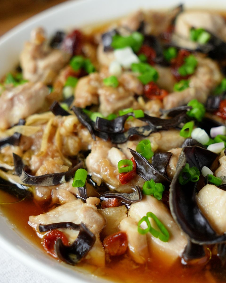 Close-up of steamed chicken thigh pieces with wood ear black fungus and goji berries