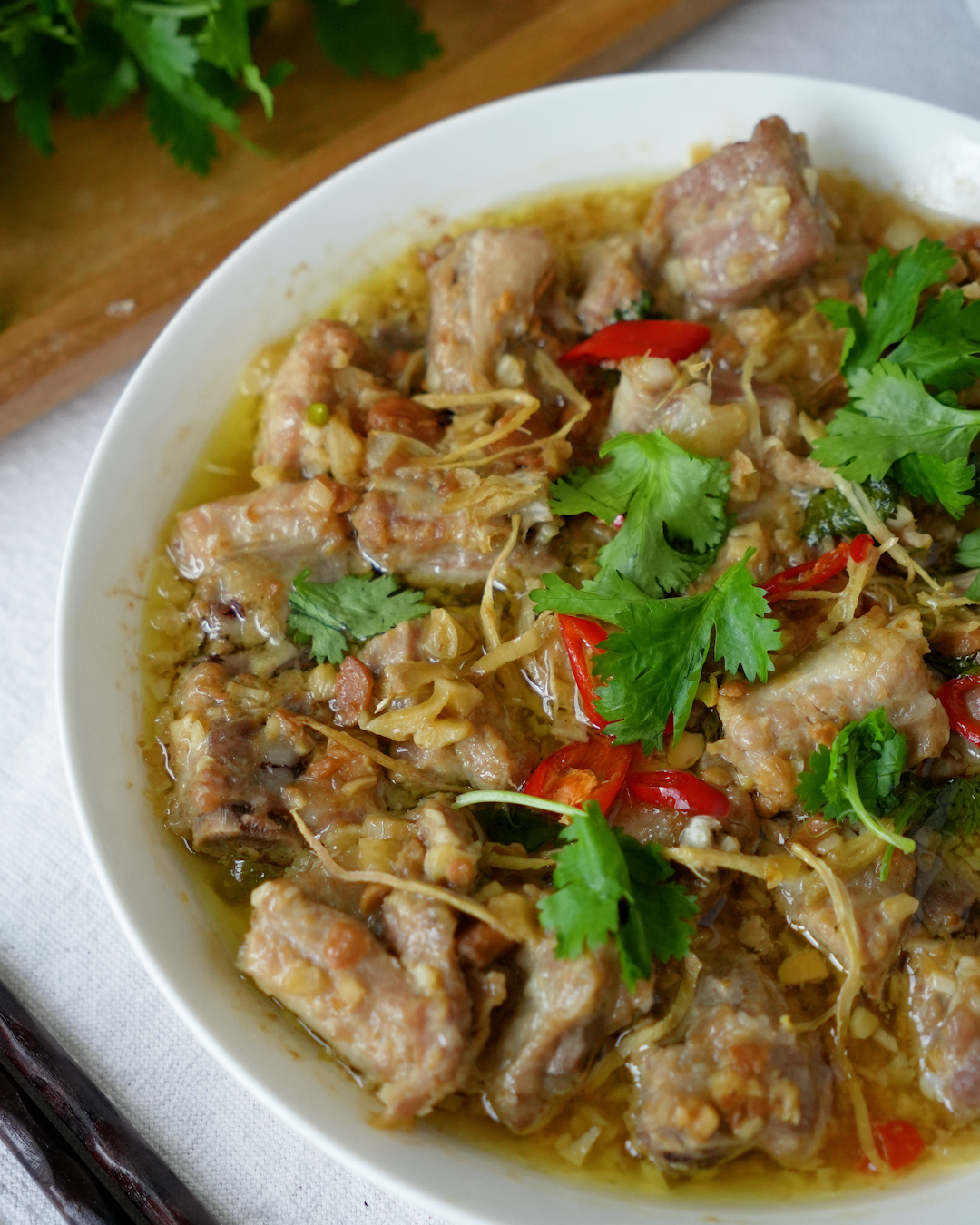 Close-up of steamed pork ribs with taucu, garlic, ginger and chilli in a white bowl