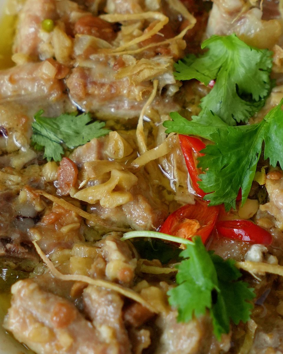 Macro shot of steamed pork ribs with taucu showing ginger, garlic and bird's eye chilli