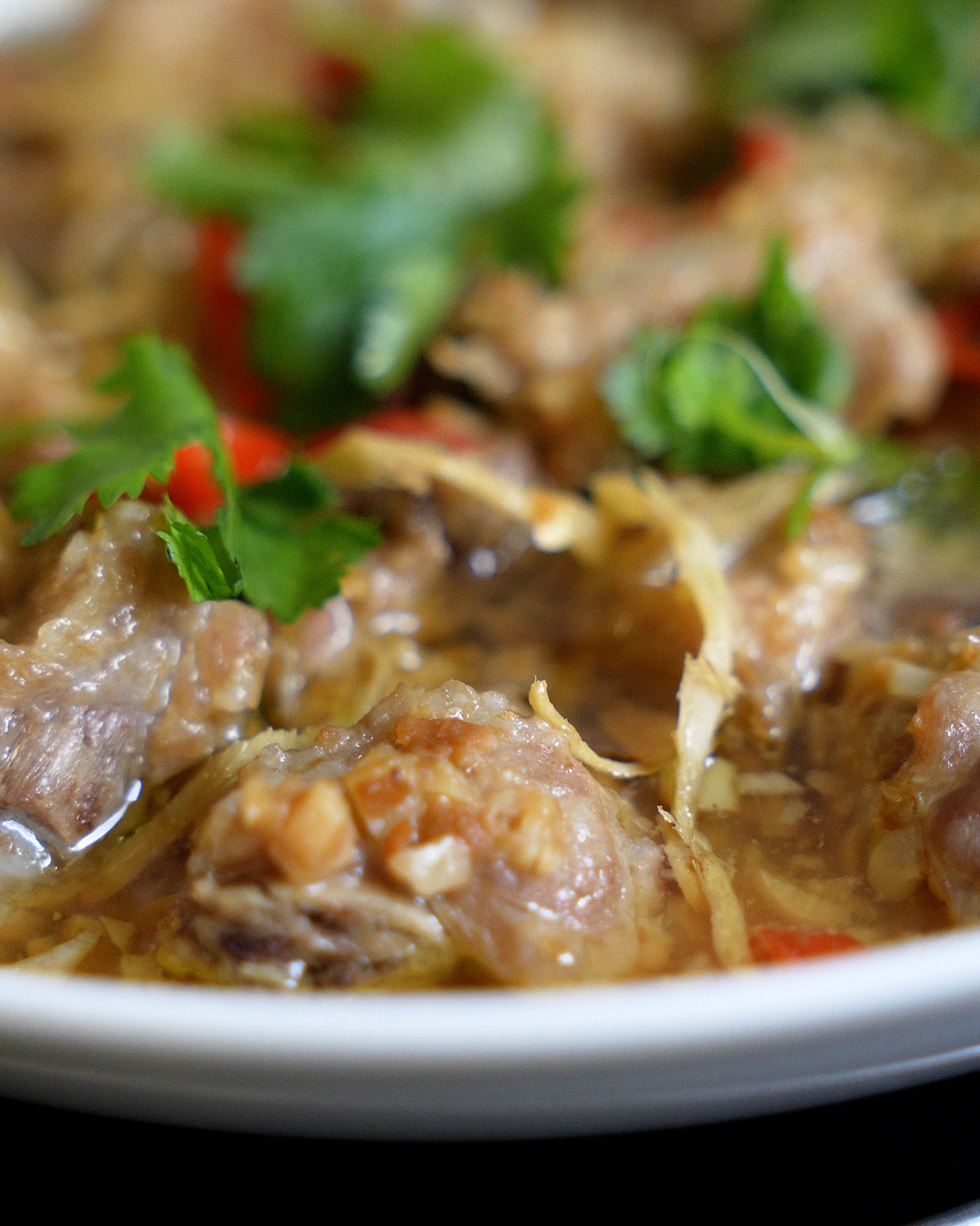 Steamed pork ribs with taucu recipe plated and garnished with coriander and red chilli