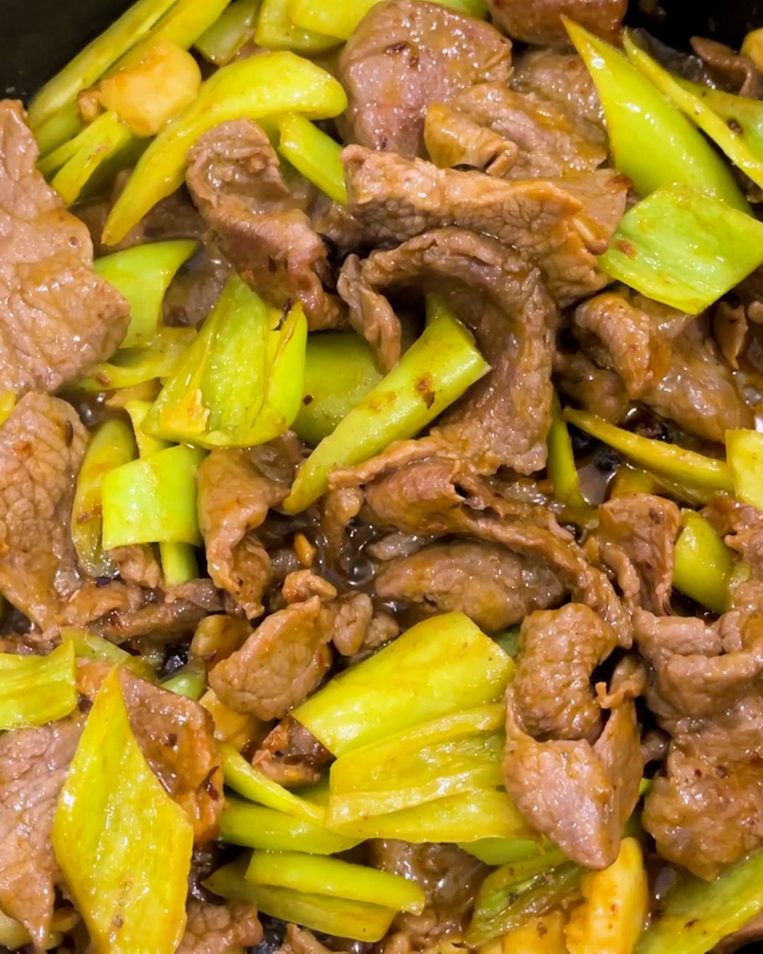 Overhead view of Chinese beef and green pepper stir fry, thinly sliced beef tossed with green chili peppers and fermented black bean paste