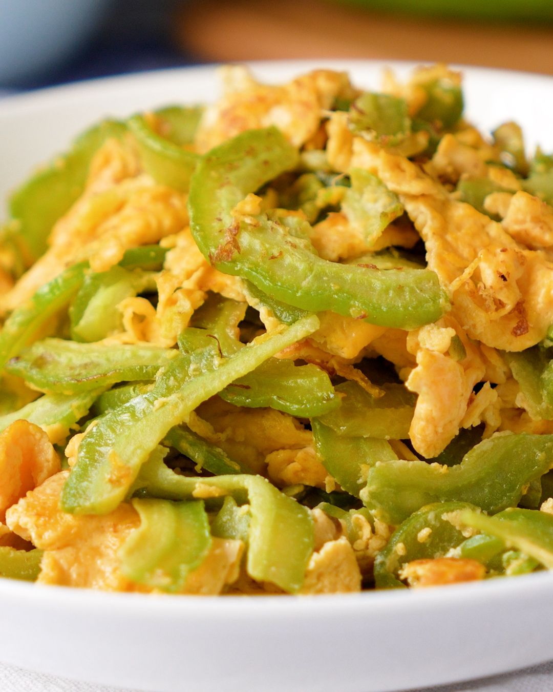 Bitter gourd stir fry with egg on a white plate