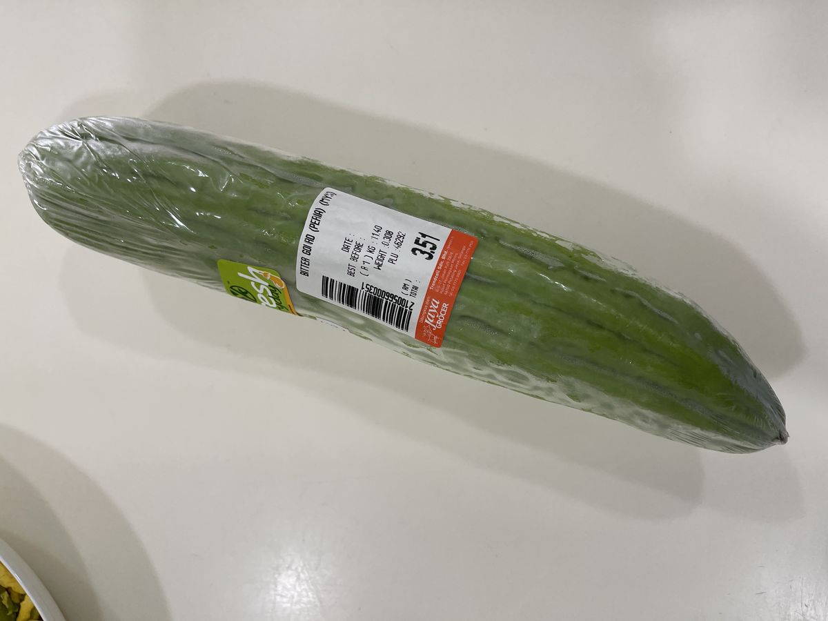 Bitter gourd wrapped in plastic from the supermarket with a price label