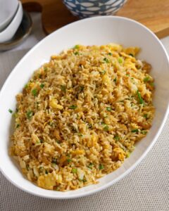 Chinese egg fried rice with dried shrimp, scrambled egg and spring onions in a white serving dish