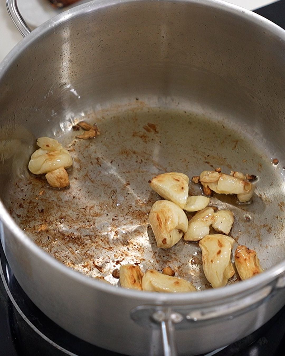 Toasting garlic cloves in a dry stainless steel pot for Chinese pork rib stew