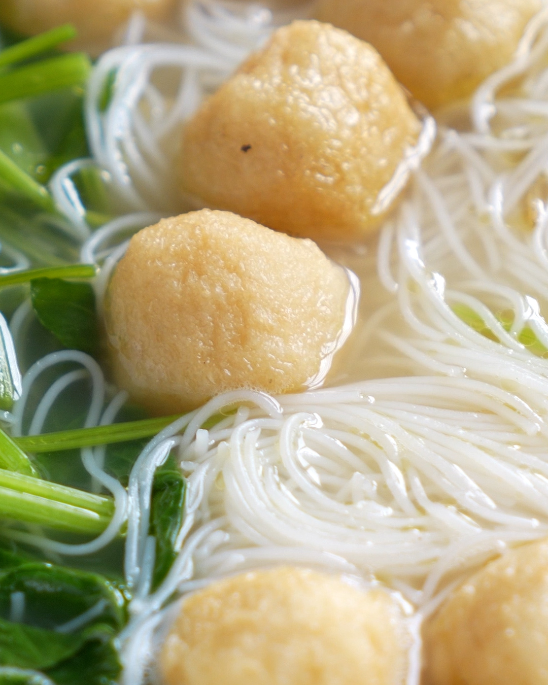 Easy fish ball noodle soup with bee hoon, fish cake and choy sum in a light ikan bilis broth, served in a claypot